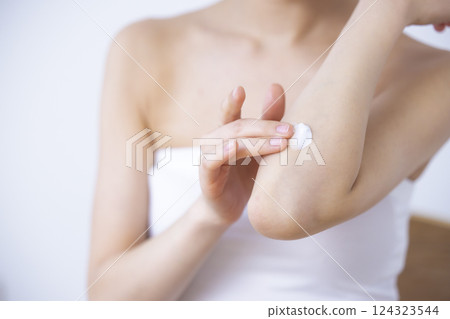 部分截圖：一位女士在手臂上塗抹潤膚霜 124323544