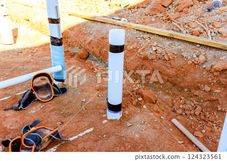 Prepare construction site with drainage PVC pipes fitting connections in trench ready for building. 124323561