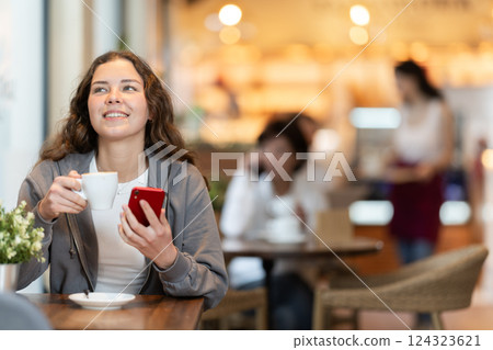 Young woman with phone in cafe 124323621