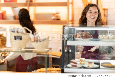 Girl saleswoman works in cafeteria bakery shop 124323648