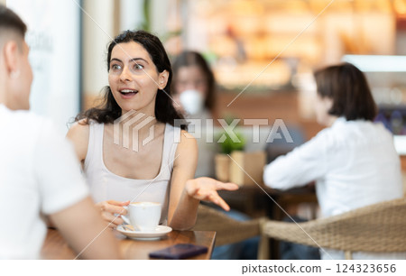 Young woman talking to guy in coffee shop 124323656