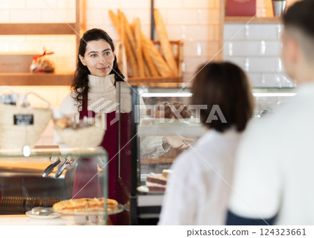 People place order at bakery, buy sweet pastries in cafeteria, young woman worker serving people 124323661