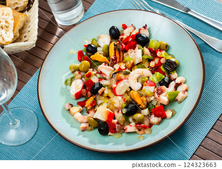 Delicious salad from variety of seafood with chopped vegetables (Salpicon de mariscos) typical for Spanish cuisine 124323663