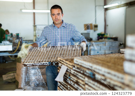 Man carrying cell seed trays in agricultural facility Man carrying cell seed trays in agricultural facility 124323779