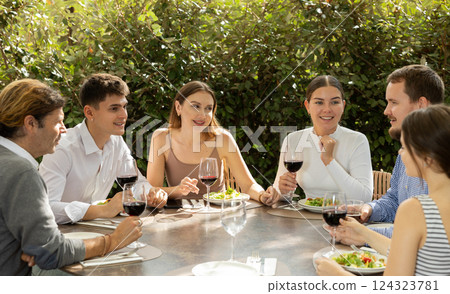 Group of friends talking and eating in restaurant 124323781