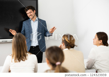 Young male teacher giving lecture to group of student 124323939