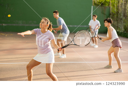 Woman playing frontenis with partners at sunny day, healthy lifestyle concept 124323990
