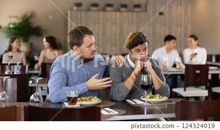 Man calms upset man in restaurant 124324019