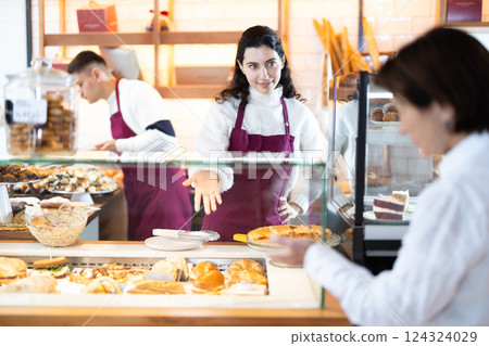 In bakery girl talk to customer, answers questions and recommends fresh products In bakery girl talk to customer, answers questions and recommends fresh products 124324029