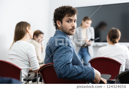 Young smiling male student sitting in college class Young smiling male student sitting in college class 124324058