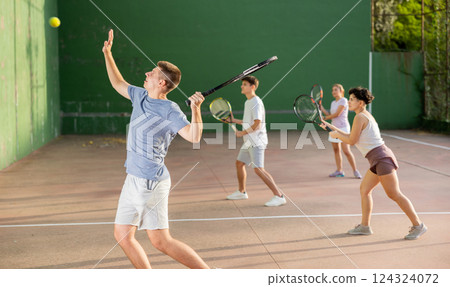 Young man playing frontenis at open-air fronton court in summer Young man playing frontenis at open-air fronton court in summer 124324072