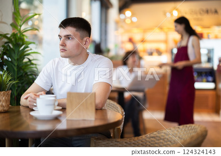 Guy drinking delicious coffee at the table 124324143