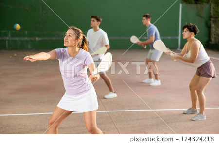 Woman Basque pelota player hitting ball with wooden racket 124324218