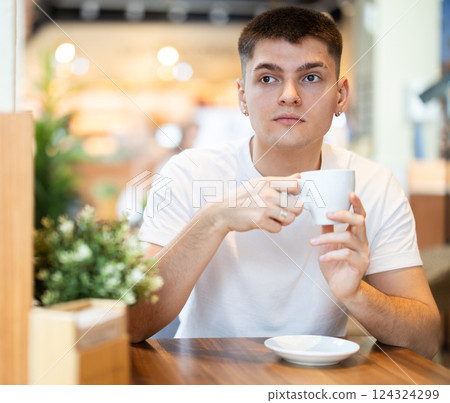 Guy drinking delicious coffee at the table 124324299