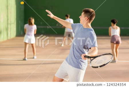 Young man serving ball during frontenis game outdoors 124324354
