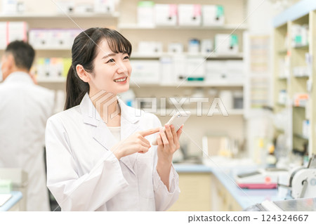 有智慧型手機的女性藥劑師（醫學筆記本、應用程式、處方、手機） 124324667