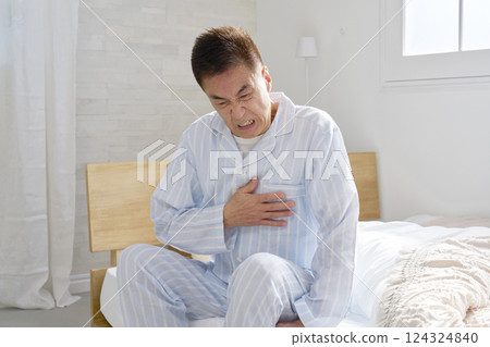 Middle-aged man in pajamas with chest pain Middle-aged man in pajamas with chest pain 124324840
