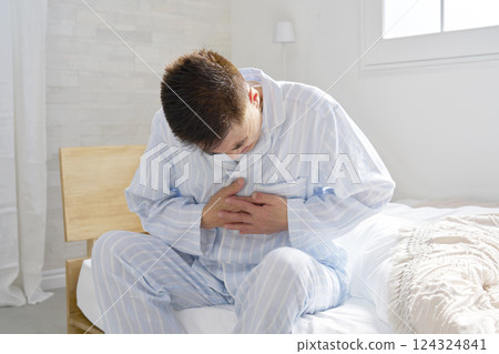 Middle-aged man in pajamas with chest pain Middle-aged man in pajamas with chest pain 124324841