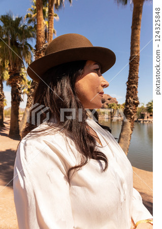 Beautiful Lebanese Woman Wearing Brown Trilby Hat Outdoor, Elegant Wool Fedora Fel. Happy Elegant Female in her 50s with White Teeth Smile. Fashion and Style. Nature on background. Vertical. Beautiful Lebanese Woman Wearing Brown Trilby Hat Outdoor, Elegant Wool Fedora Fel. Happy Elegant Female in her 50s with White Teeth Smile. Fashion and Style. Nature on background. Vertical. 124325848