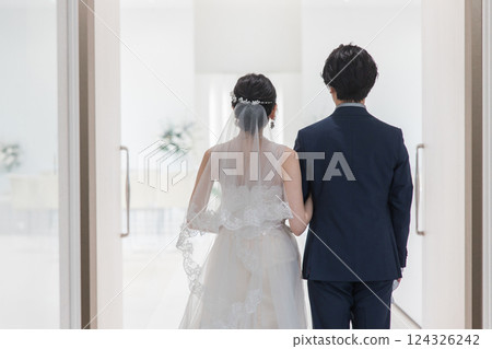 Bride and groom entering the chapel, wedding hall, and aisle at a wedding Bride and groom entering the chapel, wedding hall, and aisle at a wedding 124326242