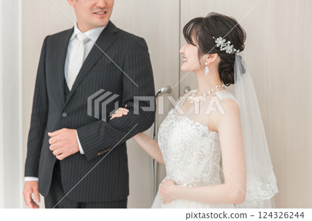 Bride/Bride's woman and father walking along a virgin road to the chapel where the groom waits at the wedding hall 124326244