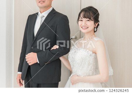 Bride/Bride's woman and father walking along a virgin road to the chapel where the groom waits at the wedding hall 124326245