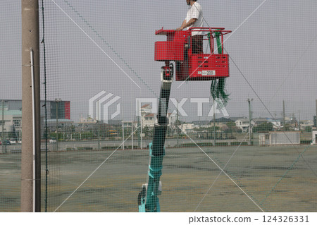 Repairing the baseball net at the civic ground 124326331