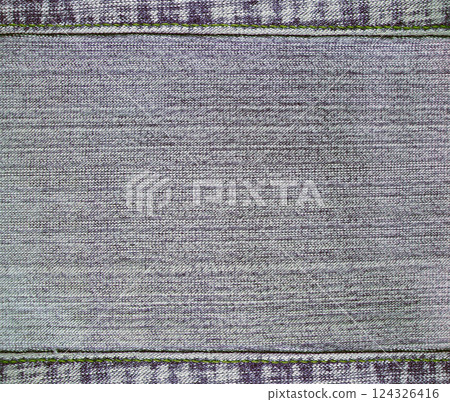 Gray denim background with a seamed frame. Grey color denim jeans fabric texture with decorative stitch border. Copy space for text 124326416
