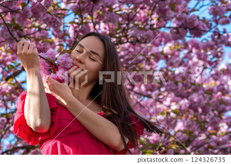 Beautiful young woman daydreaming in a cherry tree orchard Beautiful young woman daydreaming in a cherry tree orchard 124326735