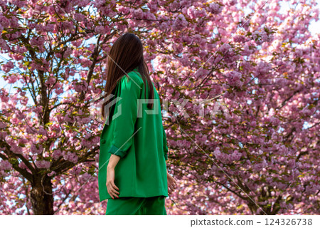 Businesswoman in a green suit connecting with nature in a cherry tree orchard Businesswoman in a green suit connecting with nature in a cherry tree orchard 124326738