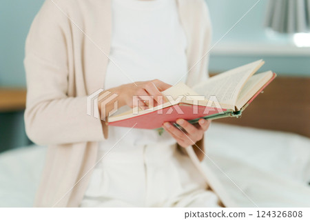坐在床邊看書的女人 124326808