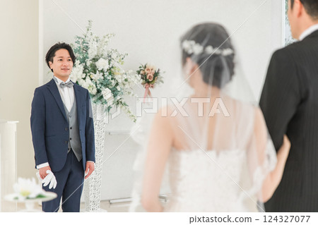 A groom/groom man waiting for a bride to walk on a virgin road at a wedding hall/chapel A groom/groom man waiting for a bride to walk on a virgin road at a wedding hall/chapel 124327077