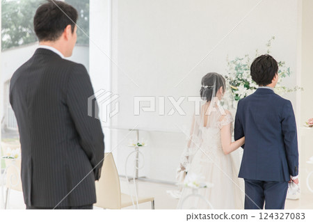Father / family watching the bride and groom walking on the virgin road at the wedding Father / family watching the bride and groom walking on the virgin road at the wedding 124327083