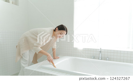 A woman cleaning a bath 124327267