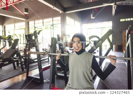 Arab middle eastern muslim woman on bench press training at the gym. Fitness exercise and healthy lifestyle concept 124327465