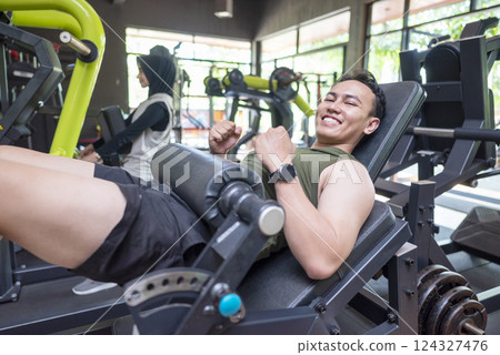 Indonesian southeast asian man training on chest press machine at the gym. Fitness exercise and healthy lifestyle concept Indonesian southeast asian man training on chest press machine at the gym. Fitness exercise and healthy lifestyle concept 124327476