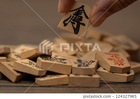 Stock photo of a person picking up one shogi piece from among many others - Image of selection Stock photo of a person picking up one shogi piece from among many others - Image of selection 124327965