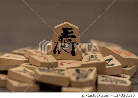 The king stands on top of many shogi pieces, giving the impression of those in power oppressing the weak. 124328186