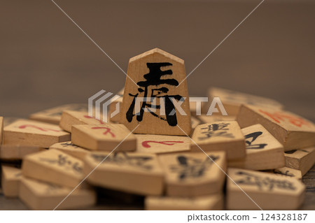 The king stands on top of many shogi pieces, giving the impression of those in power oppressing the weak. 124328187