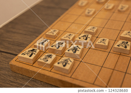 Shogi pieces are lined up on a shogi board. They are defending with the Anaguma strategy. Shogi pieces are lined up on a shogi board. They are defending with the Anaguma strategy. 124328680