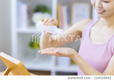美容圖片：一位女士將美容精華液滴在手上 124329082