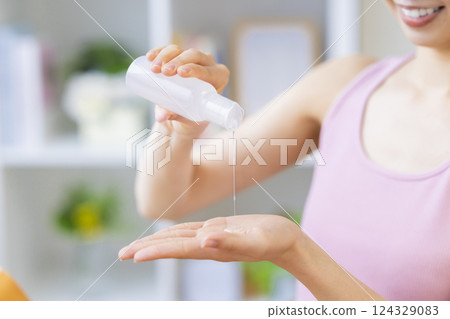 美容圖片：一位女士將美容精華液滴在手上 124329083