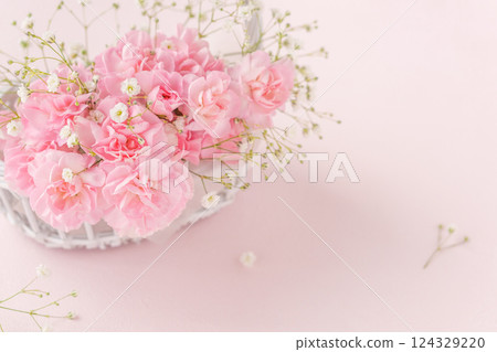 White flower basket with pink carnations White flower basket with pink carnations 124329220