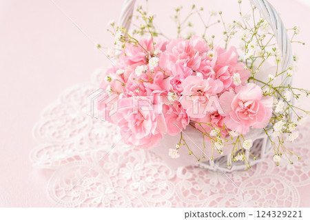 White flower basket with pink carnations White flower basket with pink carnations 124329221