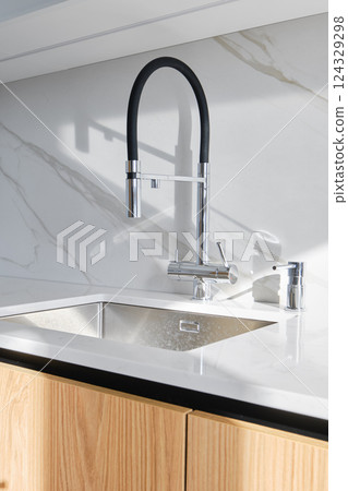 Modern kitchen design featuring a sleek faucet and elegant marble countertop 124329298