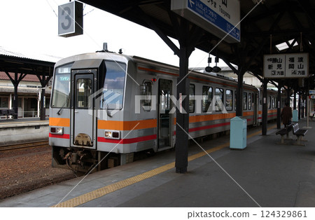 A local one-man train stopped at a rural station 124329861