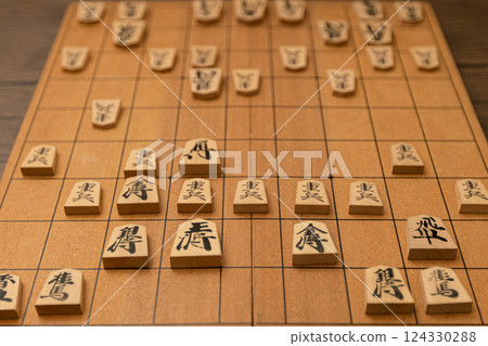 The shogi board where the game is being played. The early stages of a shogi game. The shogi board where the game is being played. The early stages of a shogi game. 124330288