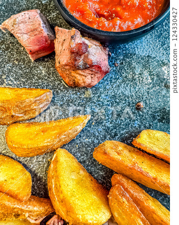 Pork steak with potato wedges and salsa sauce. High quality photo Pork steak with potato wedges and salsa sauce. High quality photo 124330427