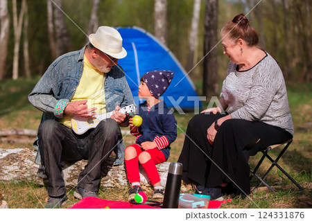 Grandma, grandpa and grandson had a picnic in the woods. Active family recreation. Grandma, grandpa and grandson had a picnic in the woods. Active family recreation. 124331876