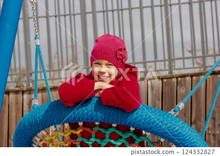 Caucasian smiling child of 8 9 years swinging on round seesaw 124332827